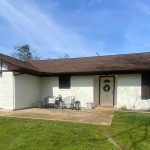 Image of a newly painted brick home with a bright, refreshed exterior replacing its previously dark, weathered look.