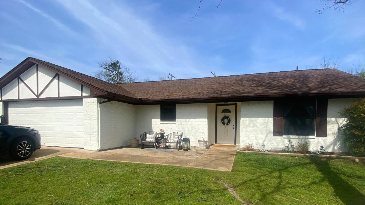 Image of a newly painted brick home with a bright, refreshed exterior replacing its previously dark, weathered look.