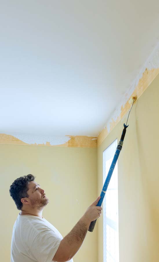 The wall is being repainted after the ceiling has been scraped and primed. Popcorn texture has been completely removed.