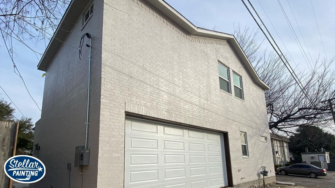 House Painters Alexandra Meadows Fort Worth, TX - Communication & Reliability - Stellar Painting This is an exterior house painting project in Alexandra Meadows Fort Worth, TX, completed by Stellar Painting, showing the side view of a white-painted brick home with a two-car garage.