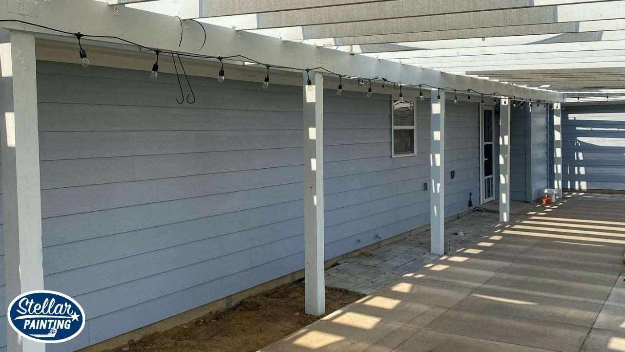 Painting Company Alexandra Meadows Fort Worth, TX - Skilled & Trained Crew - Stellar Painting This is an exterior painting project by Stellar Painting in Alexandra Meadows Fort Worth, TX, showing a light blue patio wall with white pergola overhead.